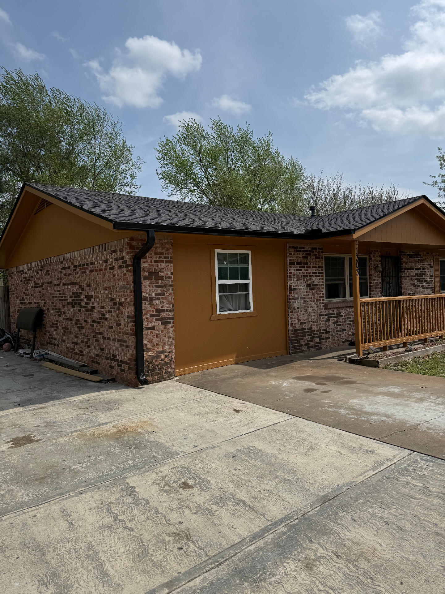 Brick home in Northwest Arkansas with black seamless gutters and downspout