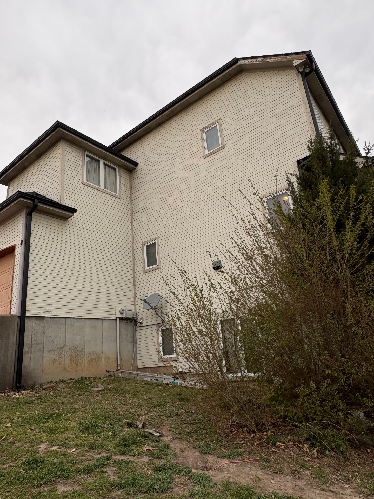 Side of a two-story home in Northwest Arkansas with black seamless gutters and downspouts