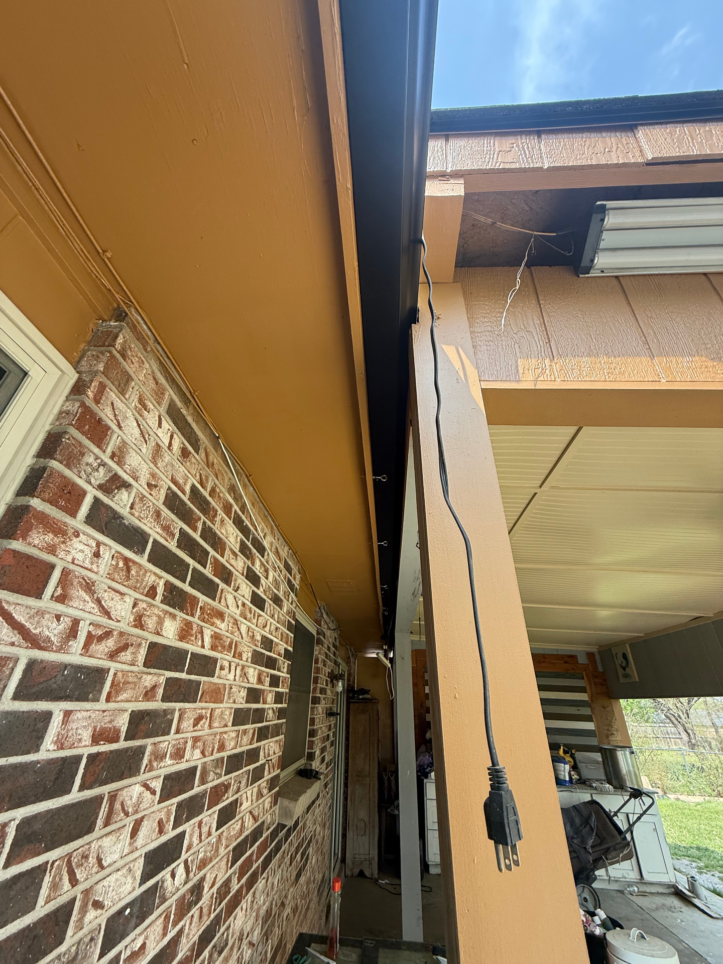 Black seamless gutter and painted soffit on a brick home in Northwest Arkansas